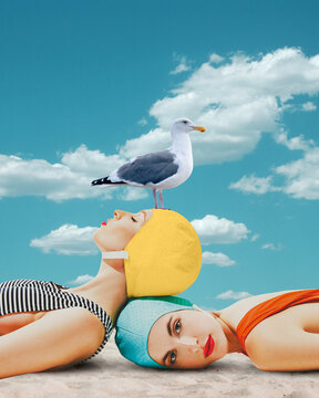 Beautiful young girls in swimming cap and swimsuits lying on beach with seagull against blue sky background. Contemporary art. Concept of summer, vacation, relaxation. Retro style. Creative design.
