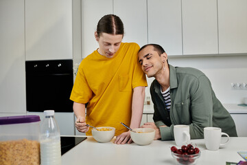 A young gay couple enjoys breakfast together in their modern apartment.
