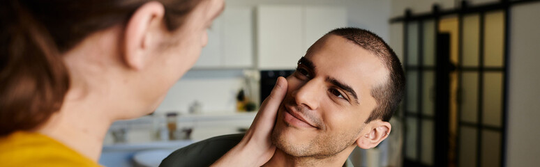 Obraz premium A young gay couple shares a tender moment in their modern apartment, showcasing their love and connection.