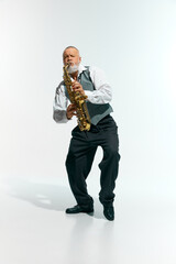 Naklejka premium Engagement with music. Bearded musician informal attire playing saxophone energetically against white studio background. Concept of music, festivals, contemporary art, hobby, creativity. Ad