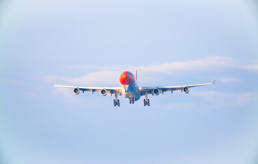 The plane lands over the sea at Phuket airport. A passenger plane lands on Mai Khao Beach, a popular tourist attraction.