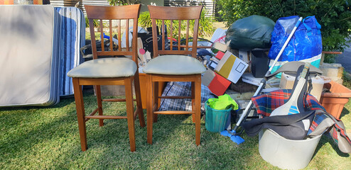 unwanted furniture and household items outside on nature strip grass, bulky waste rubbish collection going to landfill
