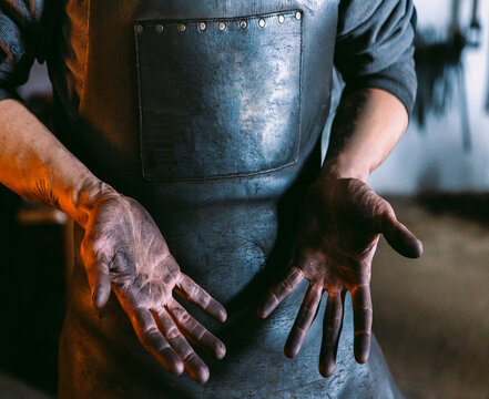 Blacksmith displaying dirty hands after hard work