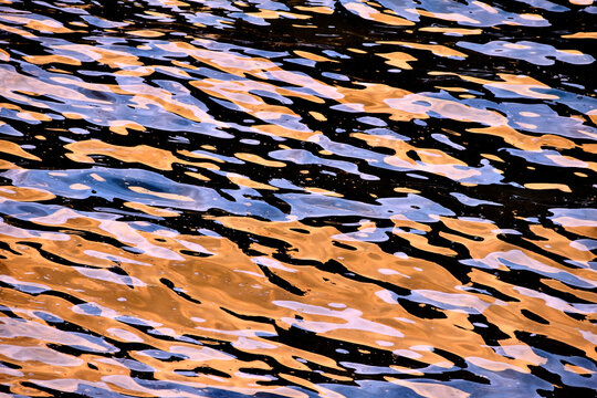 Abstract golden and blue ripples on water surface of the Cantabrian Sea