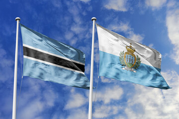 3D illustration. Botswana and  San Marino flags waving in the sky. High detailed waving flag. 3D...
