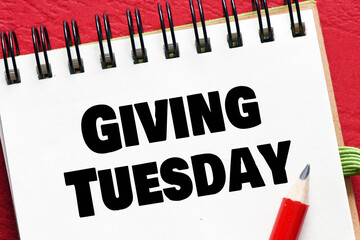 Fototapeta premium Giving Tuesday - words in an office notebook on red