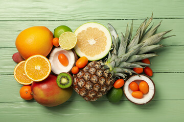 Set of tropical fruit on green wooden background, top view