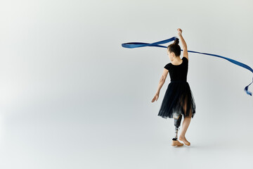 A young girl with a prosthetic leg gracefully performs a ribbon routine.