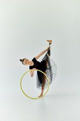 A young girl with a prosthetic leg performs a gymnastic routine with a hoop.