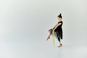 A young girl with a prosthetic leg practices gymnastics using a hula hoop.