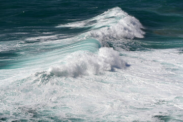 Wellenformationen mit Gischt an der Küste mit Schaumkronen