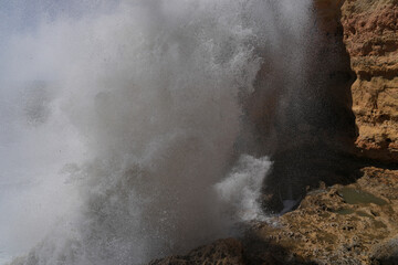 Kräftige Wellen schlagen mit Wucht an der Felswand auf 