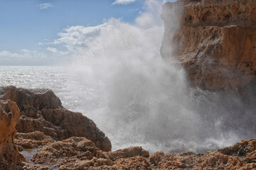 Grosse Wellen schlagen an der Sandsteinküste in der Algarve auf bei hohem Seegang 