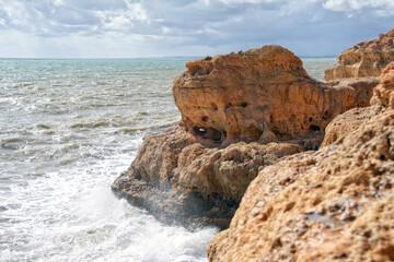 Sandsteinformationen an der Küste der Algarve mit Meeresbrandung