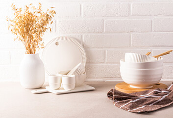 Beautiful kitchen background modern kitchen countertop with a set of kitchen utensils, , bowls, decorative elements. Front view. Brick white wall