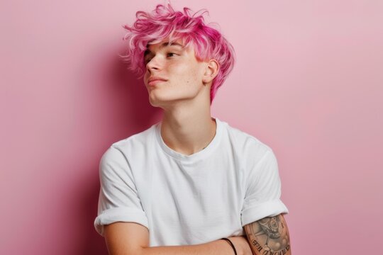 young diverse guy non binary person with pink hair wearing blank white t-shirt on pastel pink wall background with copy space