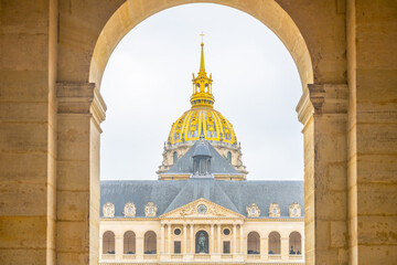 Les Invalides iconic dome glitters against the Paris sky, viewed through an archway. Paris, France