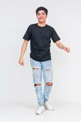Young asian man dancing awkwardly in ripped jeans and black shirt