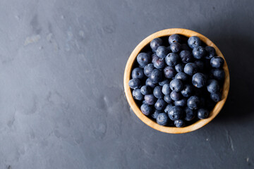 Ripe organic blueberries on black stone table background. Selective focus.