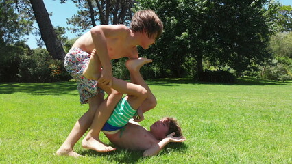 Siblings wrestling and fighting each other in rivalry