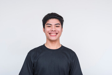 Handsome young asian man smiling in black shirt on white background
