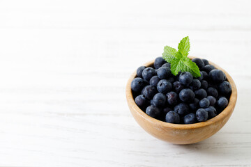Ripe organic blueberries on white wooden table background. Selective focus.