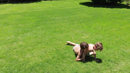 Two brothers wrestling and fighting outside © Marco