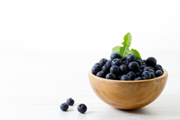 Ripe organic blueberries on white wooden table background. Selective focus.