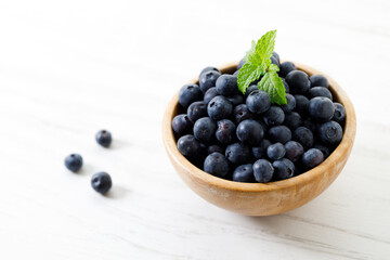 Ripe organic blueberries on white wooden table background. Selective focus.