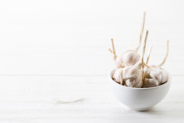 Ripe organic garlic clove and bulb on white wooden background.  Close-up. Selective focus.