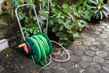 A portable tool for winding garden hoses. Concept for modern gardening equipment and urban farming.