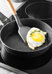 Cooking scrambled eggs using a spatula in a frying pan on the stove. Close-up