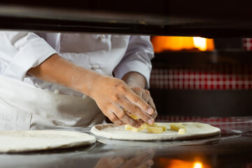 experienced chef - process of making pizza. Professional chef prepares the dough with flour to make pizza or pasta Italian food