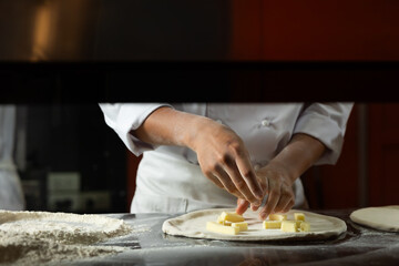 experienced chef - process of making pizza. Professional chef prepares the dough with flour to make pizza or pasta Italian food