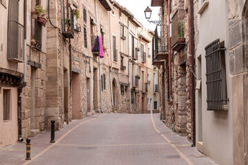 Fototapeta premium a cobblestone street lined with charming old buildings and a purple cloth hanging from a window