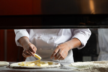 experienced chef - process of making pizza. Professional chef prepares the dough with flour to make pizza or pasta Italian food