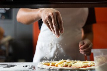 experienced chef - process of making pizza. Professional chef prepares the dough with flour to make pizza or pasta Italian food