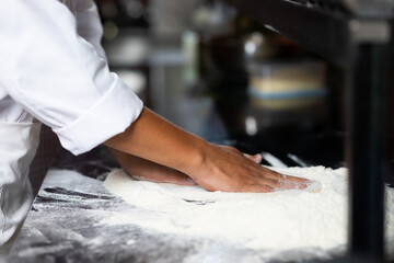 experienced chef - Professional chef prepares the dough with flour to make pizza or pasta Italian food