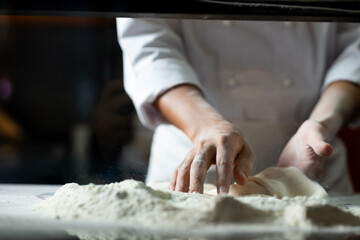 experienced chef - Professional chef prepares the dough with flour to make pizza or pasta Italian food