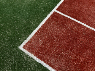 Green red artificial grass with white lines as background, top view tennis court, tennis field