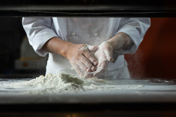 experienced chef - Professional chef prepares the dough with flour to make pizza or pasta Italian food