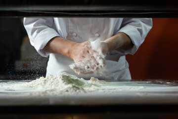 experienced chef - Professional chef prepares the dough with flour to make pizza or pasta Italian...