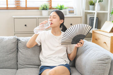 Suffering summer heat wave stroke, hot weather concept, tired asian young woman, girl drinking...
