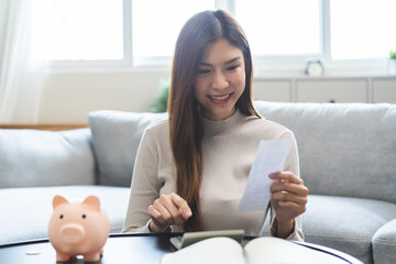 Happy asian young business woman, employee using calculator to calculate expenses of monthly, hand...