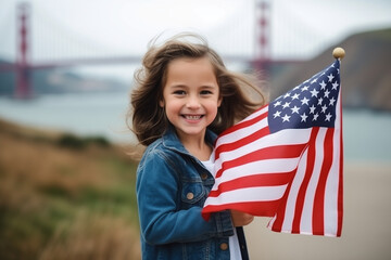 little girl staying in front of the golden gate bridge and holding the USA flag in her arm, independency day concept