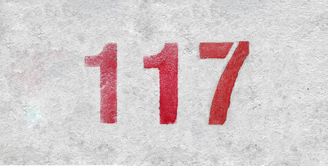 Red Number 117 on the white wall. Spray paint.