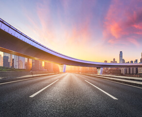 Asphalt highway road and bridge with modern city buildings at sunrise in Chongqing