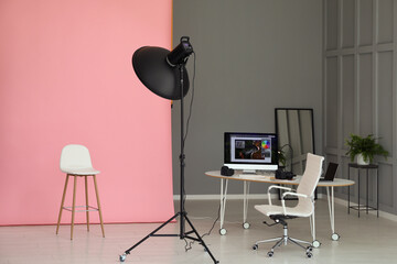 Pink photo background, workplace and professional lighting equipment in modern studio