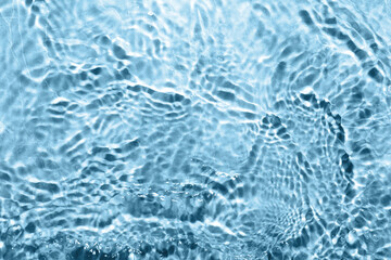 Rippled surface of clear water on light blue background, top view