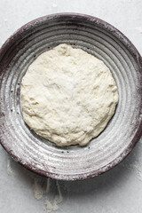 Overhead view of bread dough rising in banneton basket , top view of proofing dough in a wood proofing basket, process of making bread